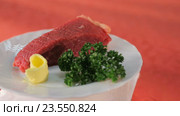 Кусок сырого мяса, красиво оформленный с зеленой петрушкой и желтым маслом на белой тарелке. Стоковое видео, видеограф Людмила Лесовая / Фотобанк Лори