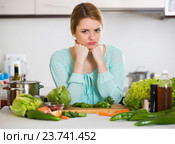 Young housewife tired of cooking vegetables in domestic kitchen. Стоковое фото, фотограф Яков Филимонов / Фотобанк Лори
