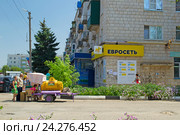Люди стоят в очереди у бочки с квасом в центре города Котельниково Волгоградской области жарким летним днём (2016 год). Редакционное фото, фотограф Светлана Шимкович / Фотобанк Лори