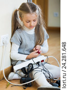 Little girl with socket extender and charging units indoors. Стоковое фото, фотограф Яков Филимонов / Фотобанк Лори