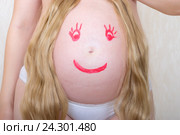 Беременная женщина с нарисованным на животе лицом. Стоковое фото, фотограф Андрей Некрасов / Фотобанк Лори