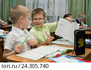 Школьник показывает свою тетрадь соседу на уроке (2015 год). Редакционное фото, фотограф Вячеслав Палес / Фотобанк Лори