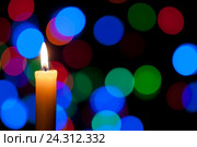 Белая Новогодняя и Рождественская свеча на чёрном фоне с размытой цветной гирляндой. Стоковое фото, фотограф Аlexander Reshetnik / Фотобанк Лори