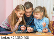 Папа показывает детям монетку через увеличительное стекло. Стоковое фото, фотограф Иванов Алексей / Фотобанк Лори