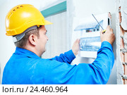 electrician installing switching electric actuator in fuse box. Стоковое фото, фотограф Дмитрий Калиновский / Фотобанк Лори