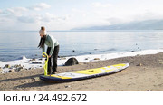 Девушка готовится плавать на sup board по зимнему озеру в Сибири. Озеро Байкал. Стоковое видео, видеограф Виталий Зверев / Фотобанк Лори