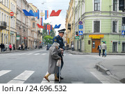 Инспектор ДПС ГИБДД переводит через дорогу пожилую женщину с тростью (2010 год). Редакционное фото, фотограф Иван Козлович / Фотобанк Лори