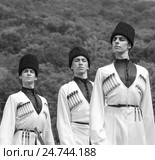Адыгея. Молодые парни в национальных костюмах танцуют традиционный танец на этнофестивале в предгорьях Кавказа, черно-белая фотография (2015 год). Редакционное фото, фотограф Андрей С / Фотобанк Лори