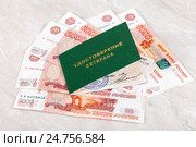 Удостоверение ветерана лежит на пятитысячных банкнотах. Редакционное фото, фотограф FotograFF / Фотобанк Лори