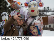 Девушка делает селфи на уличной выставке масленичных кукол "Сударыня Масленица " в сквере на улице Андропова в центре города Ярославля, Россия (2016 год). Редакционное фото, фотограф Николай Винокуров / Фотобанк Лори