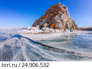 Shaman Rock or Cape Burhan on Olkhon Island in winter, surrounded by the blue ice of Lake Baikal with cracks. Стоковое фото, фотограф Zakirov Aleksey / Фотобанк Лори