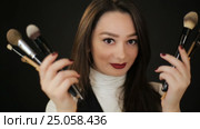 Woman hiding behind makeup brushes. Стоковое видео, видеограф Илья Шаматура / Фотобанк Лори