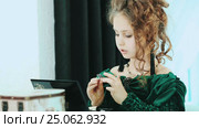 Young girl with curls in hair, sitting front the mirror puts ring. Стоковое видео, видеограф Сергей Мнацаканов / Фотобанк Лори