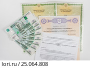 На белом фоне два свидетельства о рождении, сертификат на материнский капитал, уведомление о получении сертификата и пачка денег. Стоковое фото, фотограф Иванов Алексей / Фотобанк Лори