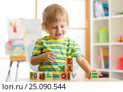 Little preschooler child boy playing with toy cubes and memorizing letters. Early education concept. Стоковое фото, фотограф Оксана Кузьмина / Фотобанк Лори