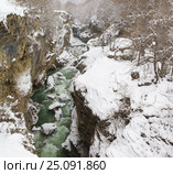 Бурлящий поток зеленой холодной воды реки Белой в узком каменном заснеженном ущелье Хаджохская теснина на окраине поселка Каменномостский (Адыгея) в зимний деньна холодный зимний день. Стоковое фото, фотограф Наталья Гармашева / Фотобанк Лори