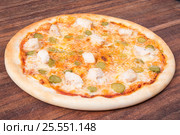 Hot pizza slice with melting cheese on a rustic wooden table. Стоковое фото, фотограф Aleksandr Ryzhov / Фотобанк Лори