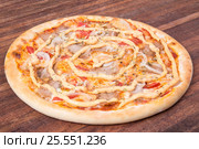 Hot pizza slice with melting cheese on a rustic wooden table. Стоковое фото, фотограф Aleksandr Ryzhov / Фотобанк Лори