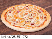 Hot pizza slice with melting cheese on a rustic wooden table. Стоковое фото, фотограф Aleksandr Ryzhov / Фотобанк Лори
