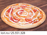 Hot pizza slice with melting cheese on a rustic wooden table. Стоковое фото, фотограф Aleksandr Ryzhov / Фотобанк Лори