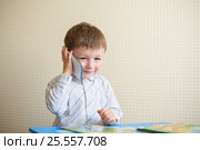Little boy sitting at desk and talking on the phone. Стоковое фото, фотограф Happy Letters / Фотобанк Лори
