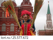 Красивая девушка в русском национальном костюме на ходулях на Манежной площади города Москвы во время празднования Масленицы, Россия (2017 год). Редакционное фото, фотограф Николай Винокуров / Фотобанк Лори