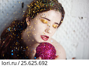 Girl with makeup sequins strewn holding purple brilliant ball. Стоковое фото, фотограф Dmitry Chapurin / Фотобанк Лори