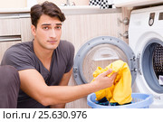 Young husband man doing laundry at home. Стоковое фото, фотограф Elnur / Фотобанк Лори