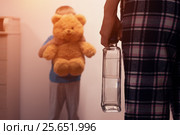 Boy covering his face with toy from drunk mother. Стоковое фото, фотограф Pavel Biryukov / Фотобанк Лори