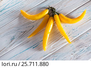 Yellow chili pepper on a wooden light background. View from above. Стоковое фото, фотограф Татьяна Дубчук / Фотобанк Лори