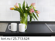 Pink tulips bouquet in glass vase on the kitchen. Стоковое фото, фотограф Дарья Петренко / Фотобанк Лори