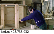Carpenter applying glue on wooden plank with brush. Стоковое видео, видеограф Швец Анастасия / Фотобанк Лори