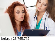Two female doctors looking at patient information form. Стоковое фото, фотограф Людмила Дутко / Фотобанк Лори