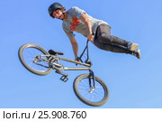 PERM, RUSSIA - August 20, 2016: Young man in a protective helmet on his head jumping in aeromat at the event in Perm region. Редакционное фото, фотограф Светлана Додух / Фотобанк Лори