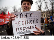 Участниr митинга КПРФ против ухудшения социального положения граждан России на площади Революции в городе Москве держит плакат с надписью "Хочу честного премьера" (2017 год). Редакционное фото, фотограф Николай Винокуров / Фотобанк Лори
