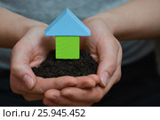 Female hands holding a piece of land with wooden house. Стоковое фото, фотограф Сергей Дорошенко / Фотобанк Лори
