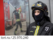 Сотрудник добровольной пожарной охраны МЧС города Москвы готовится приступить к тушению пожара, Россия (2017 год). Редакционное фото, фотограф Николай Винокуров / Фотобанк Лори