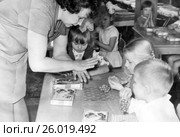 Воспитательница учит детей лепить виноград из пластилина. 1968 год. (2017 год). Редакционное фото, фотограф Светлана Попова / Фотобанк Лори