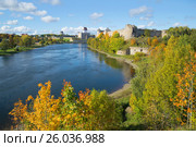 Золотая осень на пограничной реке Нарва. Вид на русскую Ивангородскую крепость и эстонский замок Германа. Граница между Эстонией и Россией (2015 год). Стоковое фото, фотограф Виктор Карасев / Фотобанк Лори