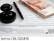 Оплата налогов. Налоговая декларация, российские деньги, авторучка и печать предприятия. Стоковое фото, фотограф Игорь Низов / Фотобанк Лори