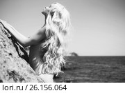 Молодая сексуальная девушка загорает с голым телом на нудистском пляже на фоне моря. Обнаженная красивая женщина с идеальной фигурой раздевается на природе. эротика с длинноволосой голой моделью занимающейся нудизмом. Стоковое фото, фотограф Майер Георгий Владимирович / Фотобанк Лори