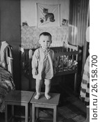 Малыш стоит на табурете в жилой комнате. 1961 год. (2017 год). Редакционное фото, фотограф Светлана Попова / Фотобанк Лори