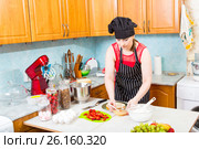 Девушка на кухне пропитывает корж праздничного торта. Стоковое фото, фотограф Сергей Дубров / Фотобанк Лори