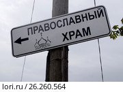 Табличка-указатель "Православный храм" на старом деревянном столбе в пасмурную, дождливую погоду. Стоковое фото, фотограф Владимир Половов / Фотобанк Лори