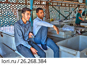 Two young Iranians are resting at entrance to  fish market (2017 год). Редакционное фото, фотограф Владимир Григорьев / Фотобанк Лори