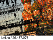 Diagonal view on workers on stage construction levels at Moscow Red Square in front of Vasiliy Blazhenniy Cathedral. Workers shadow figures on staging construction. Pop music stage under construction (2005 год). Редакционное фото, фотограф Mikhail Leonov / Фотобанк Лори