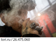 Посетитель выставки Vape Show курит электронные сигареты в городе Москве,  Россия (2017 год). Редакционное фото, фотограф Николай Винокуров / Фотобанк Лори
