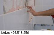 A man removes the old ceramic tile from the wall in the bathroom. Стоковое видео, видеограф Андрей Радченко / Фотобанк Лори