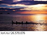 Playing and swimming kids in sea over beautifil sunrise in Thai. Стоковое фото, фотограф Roman Barelko / Фотобанк Лори