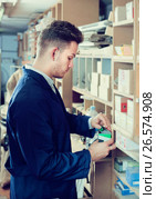 Young male joiner searching for items at workplace. Стоковое фото, фотограф Яков Филимонов / Фотобанк Лори